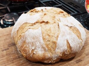 Soft, freshly baked bread loaf dusted with flour, perfect for home baking or bakery display.