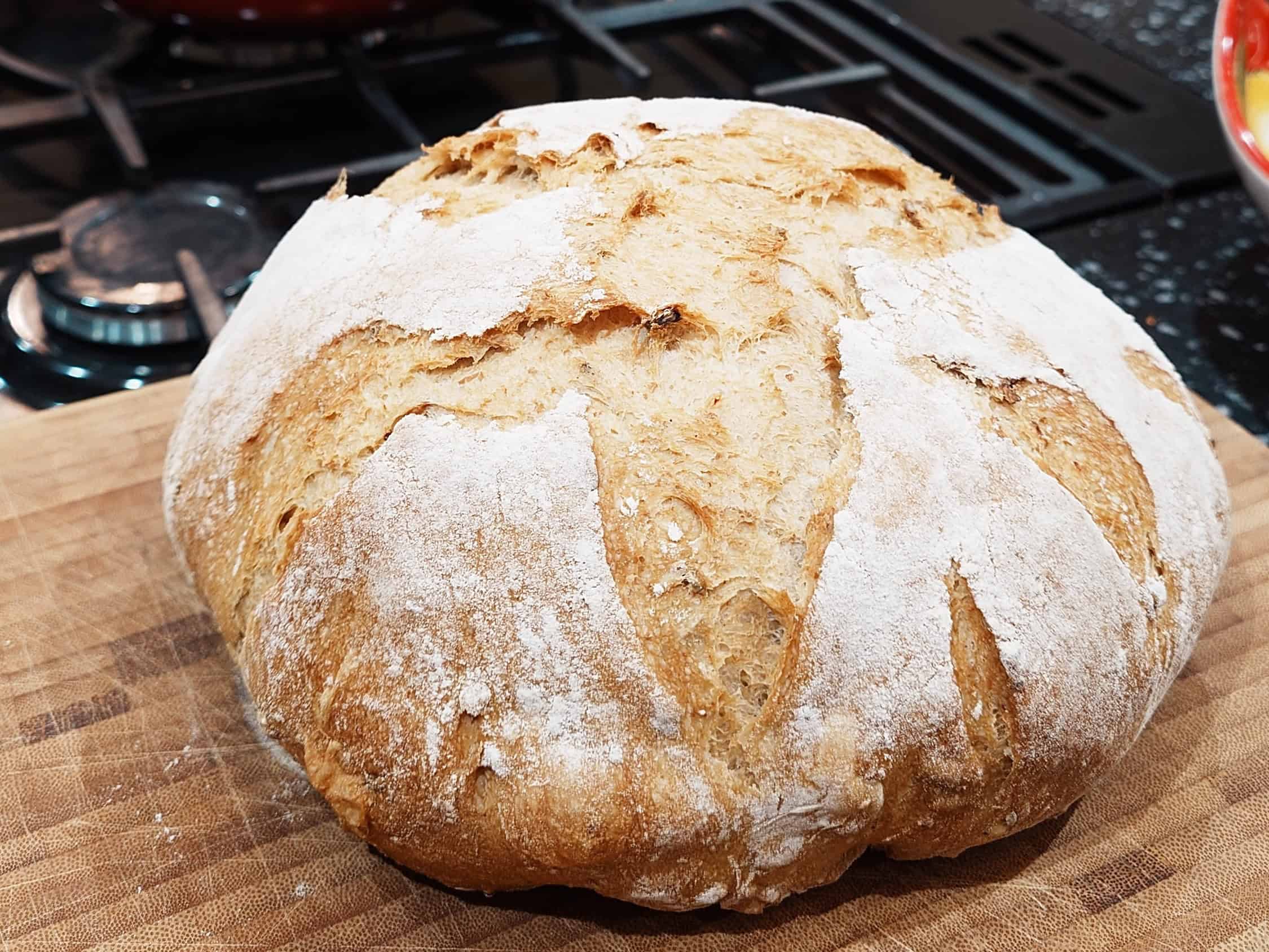 Soft, freshly baked bread loaf dusted with flour, perfect for home baking or bakery display.