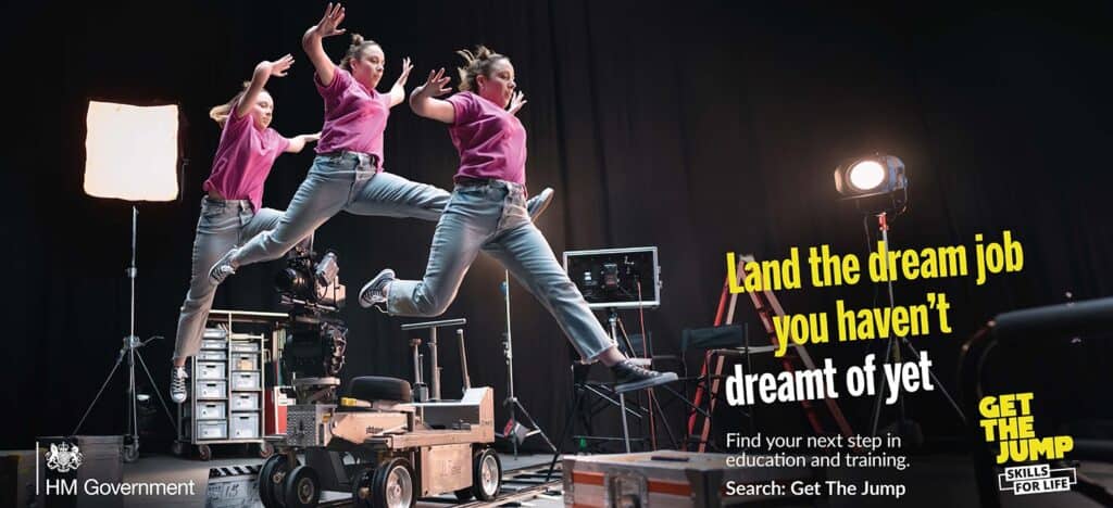 Leaping students in pink shirts and jeans on a film set with professional lighting and camera equipment for The Study Buddy website, promoting education and training opportunities.