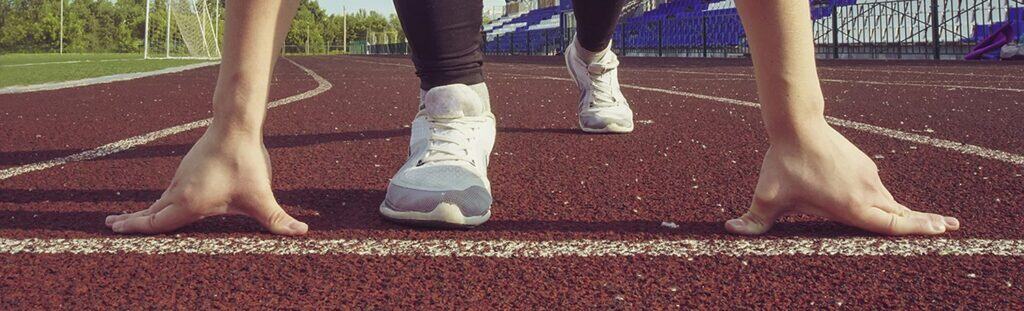 Starting line at the athletics track, ready for a race or training session, showcasing determination and focus for students and athletes using The Study Buddy website.